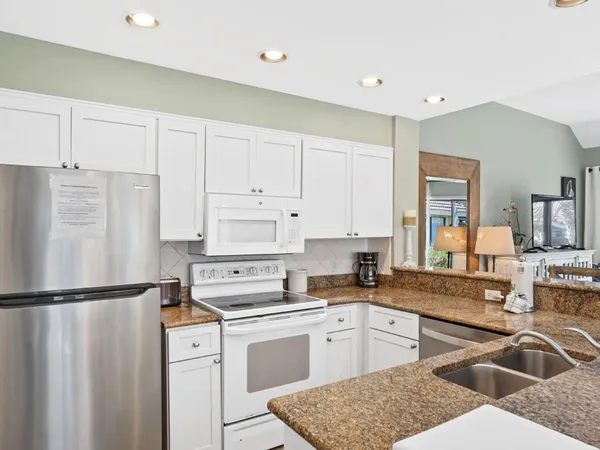 a kitchen with a refrigerator sink and cabinets