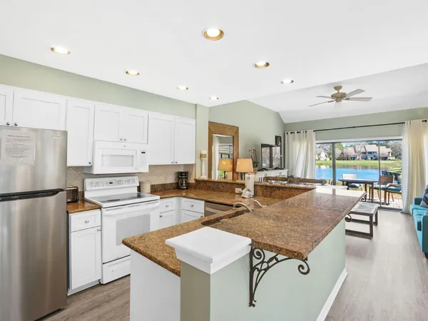 a kitchen with stainless steel appliances granite countertop table chairs sink and cabinets