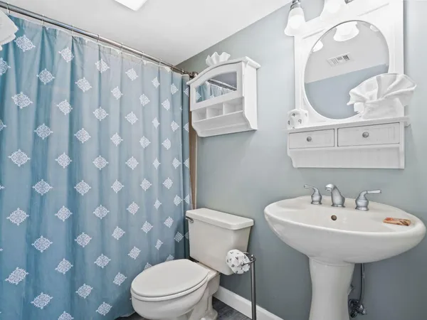 a bathroom with a sink toilet and a mirror