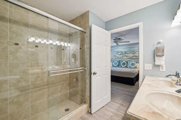 a en suite spacious bathroom with a granite countertop tub shower and mirror