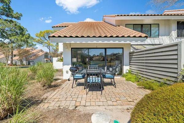 a patio with a table and chairs and potted plants