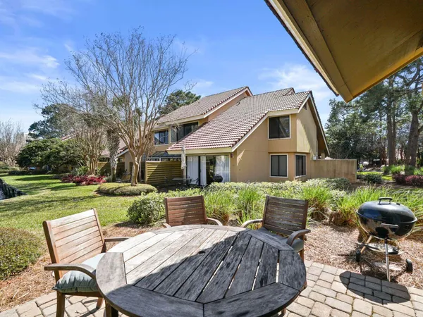 a view of a house with backyard sitting area and furniture