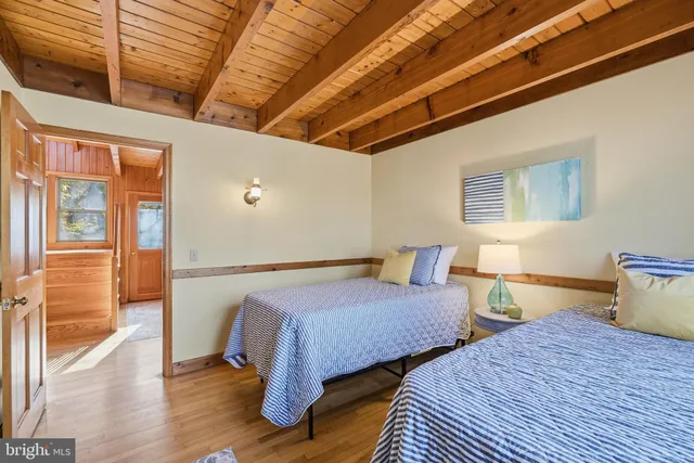 a bedroom with two beds and wooden floor