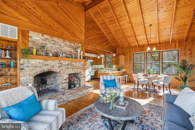 a living room with furniture a fireplace and large windows