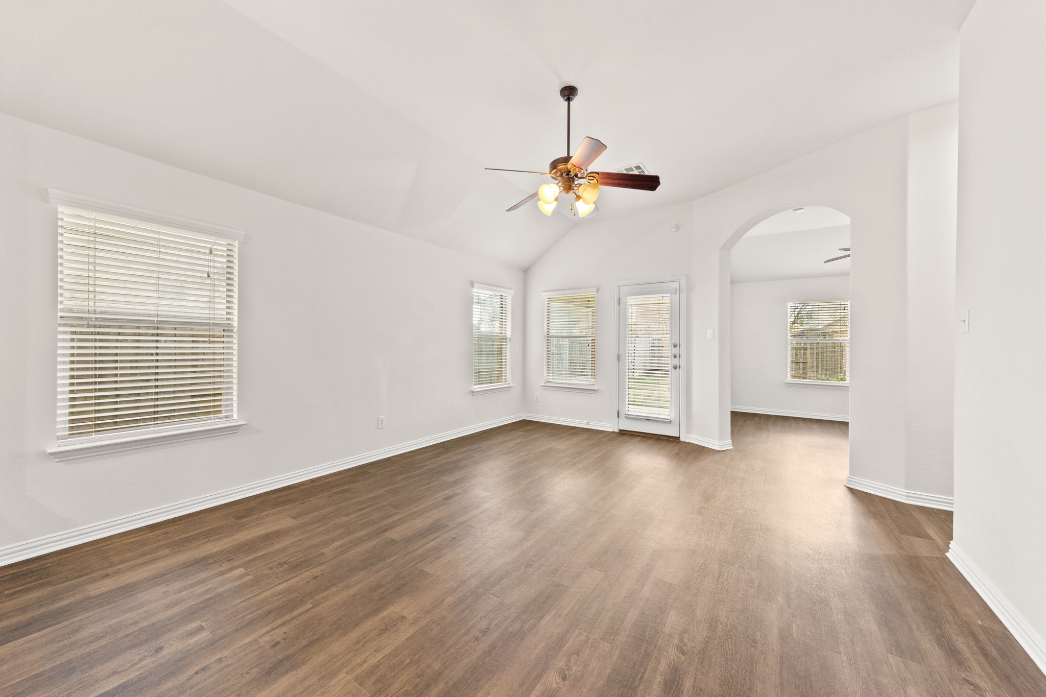411 Tascate Street Georgetown, TX 78628 - Photo 15 of 41 A spacious living area with vaulted ceilings and durable hardwood-style flooring.