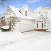 a view of a white house with a yard covered in snow