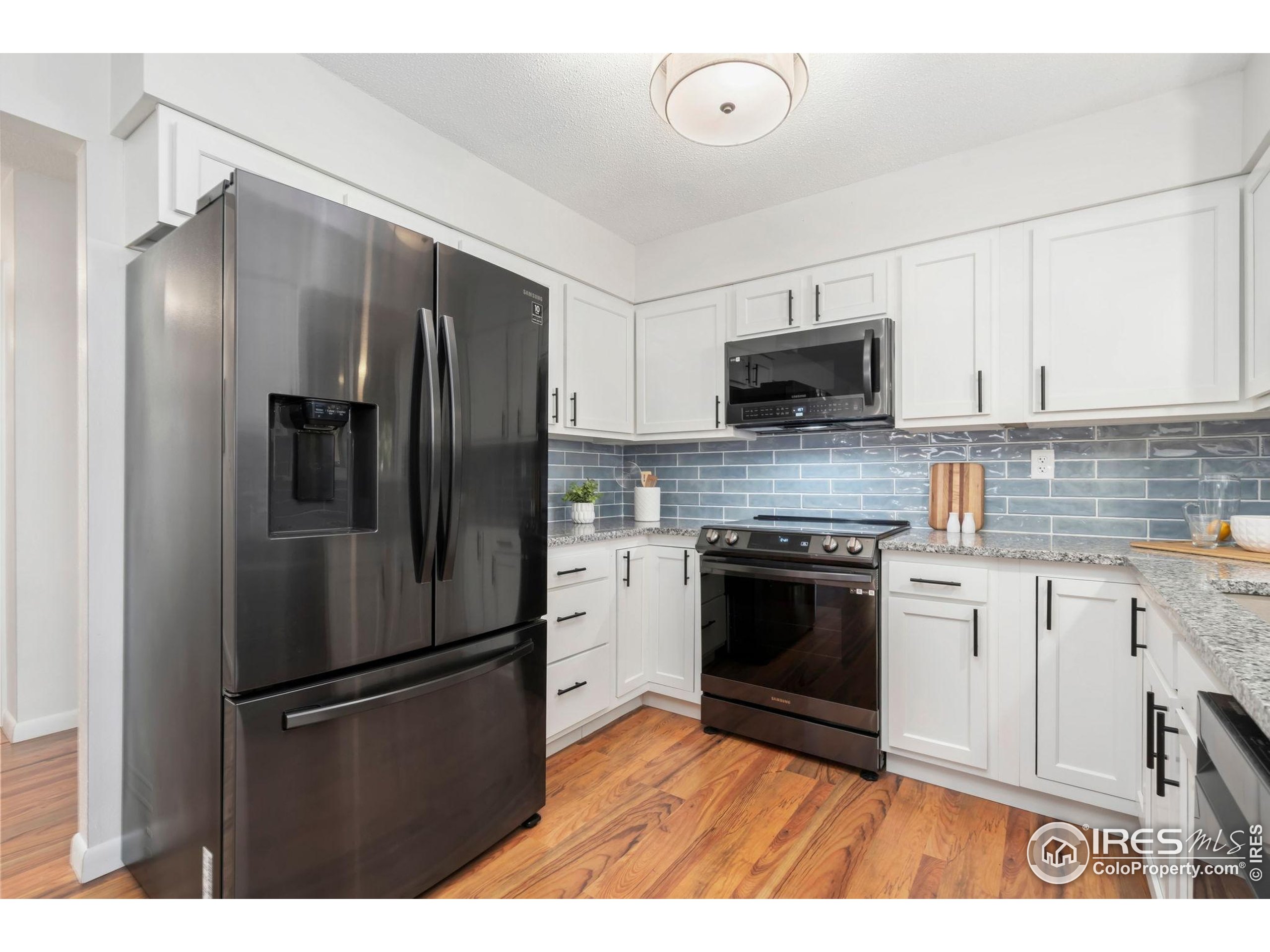 435 Birch Avenue Eaton, CO 80615 - Photo 8 of 32 a kitchen with granite countertop a refrigerator stove and microwave