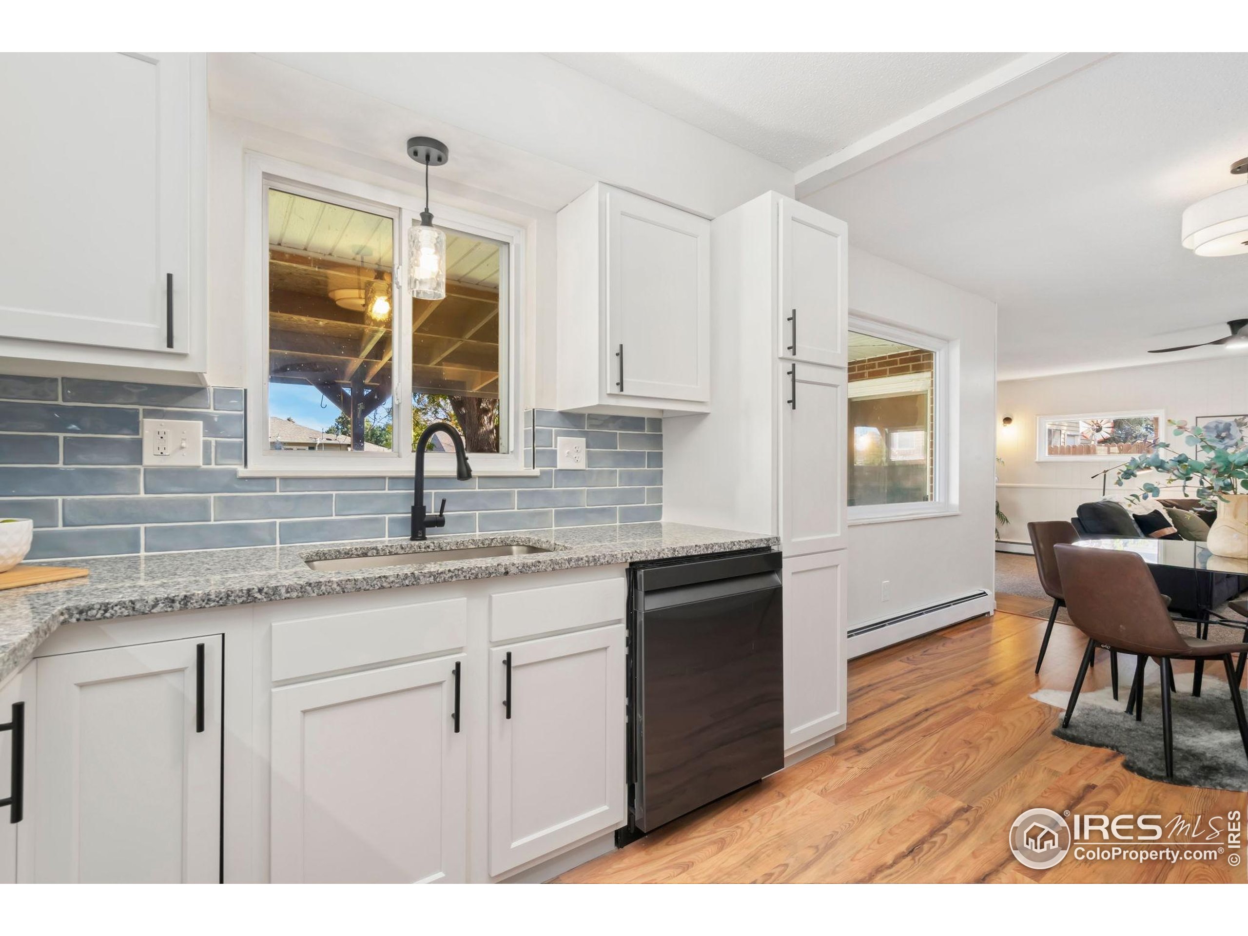 435 Birch Avenue Eaton, CO 80615 - Photo 9 of 32 a kitchen with granite countertop a sink cabinets and wooden floor