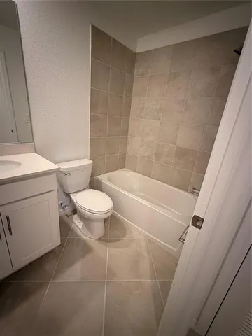 a white toilet sitting next to a bath tub