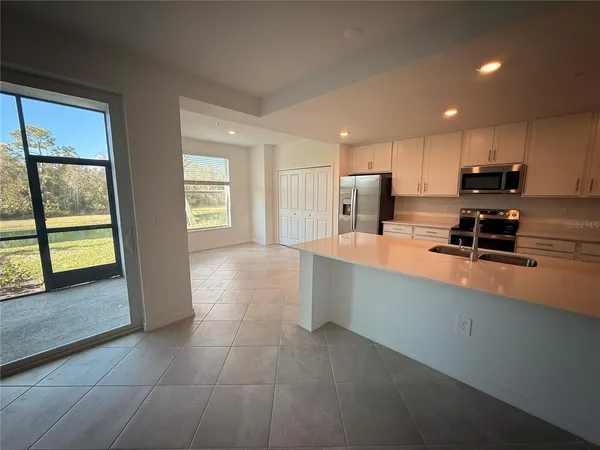 a large kitchen with stainless steel appliances a sink a stove and a window