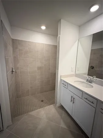 a bathroom with a shower sink and mirror