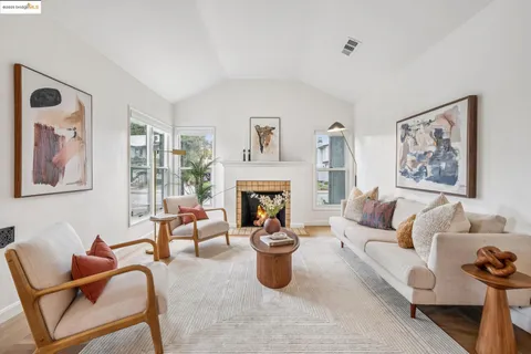 a living room with furniture a fireplace and a large mirror