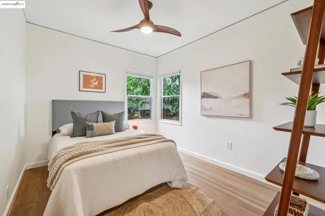 a spacious bedroom with a bed a chandelier and a window