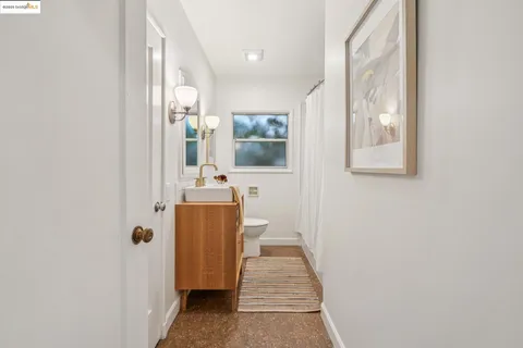 a spacious bedroom with a bed and a painting on the wall
