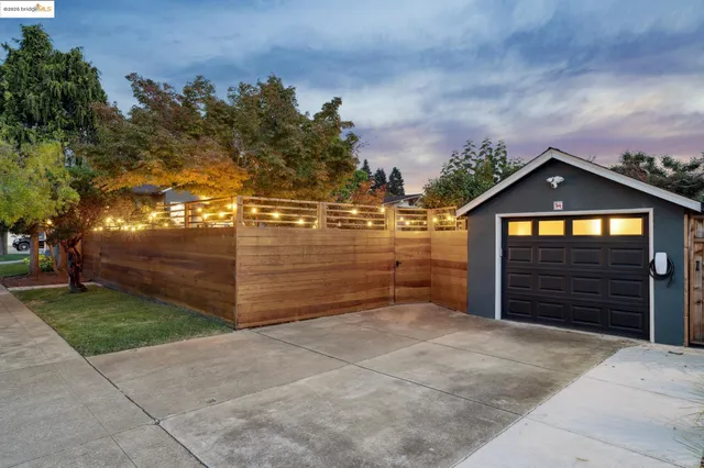 a view of a patio with table and chairs with wooden fence and plants