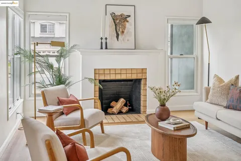 a living room with furniture a fireplace and a large mirror