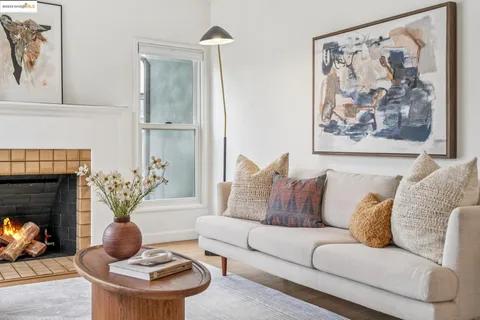 a living room with furniture a fireplace and paintings on the wall