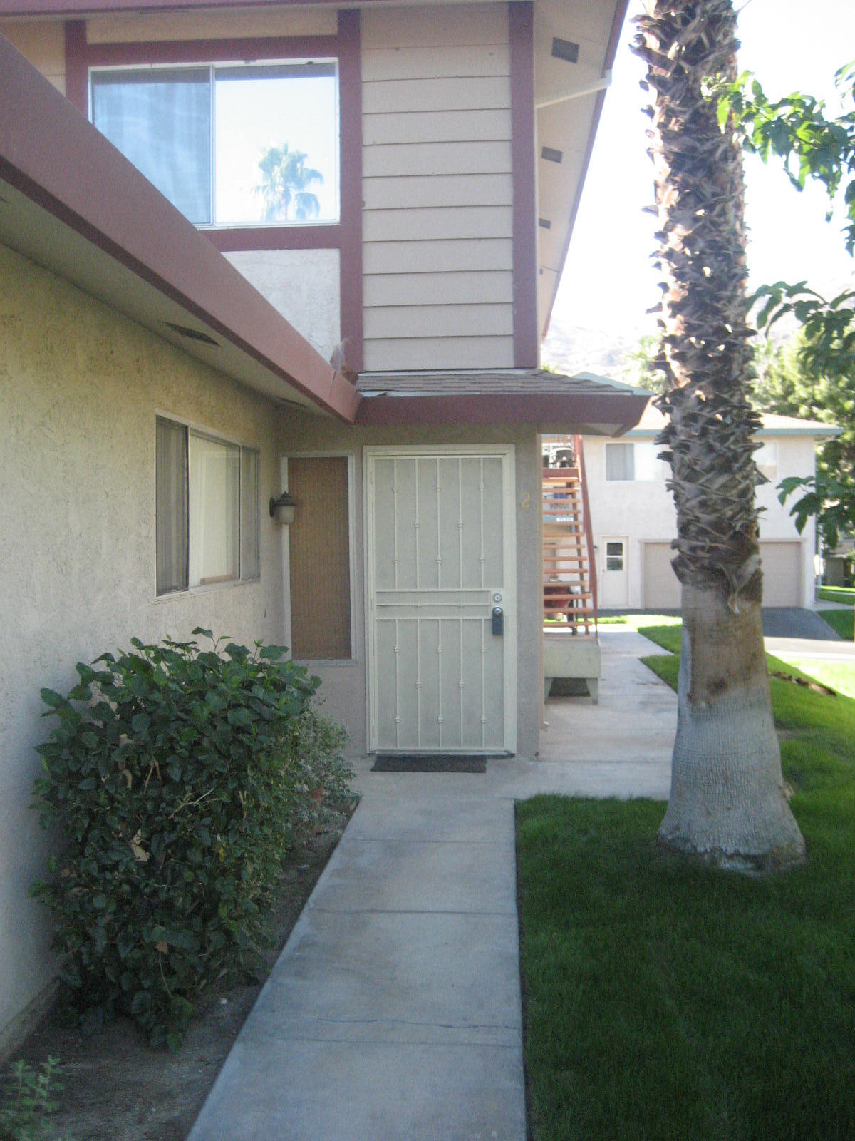72724 Eagle Road, Unit 2 Palm Desert, CA 92260 - Photo 1 of 29 a front view of a house with garden