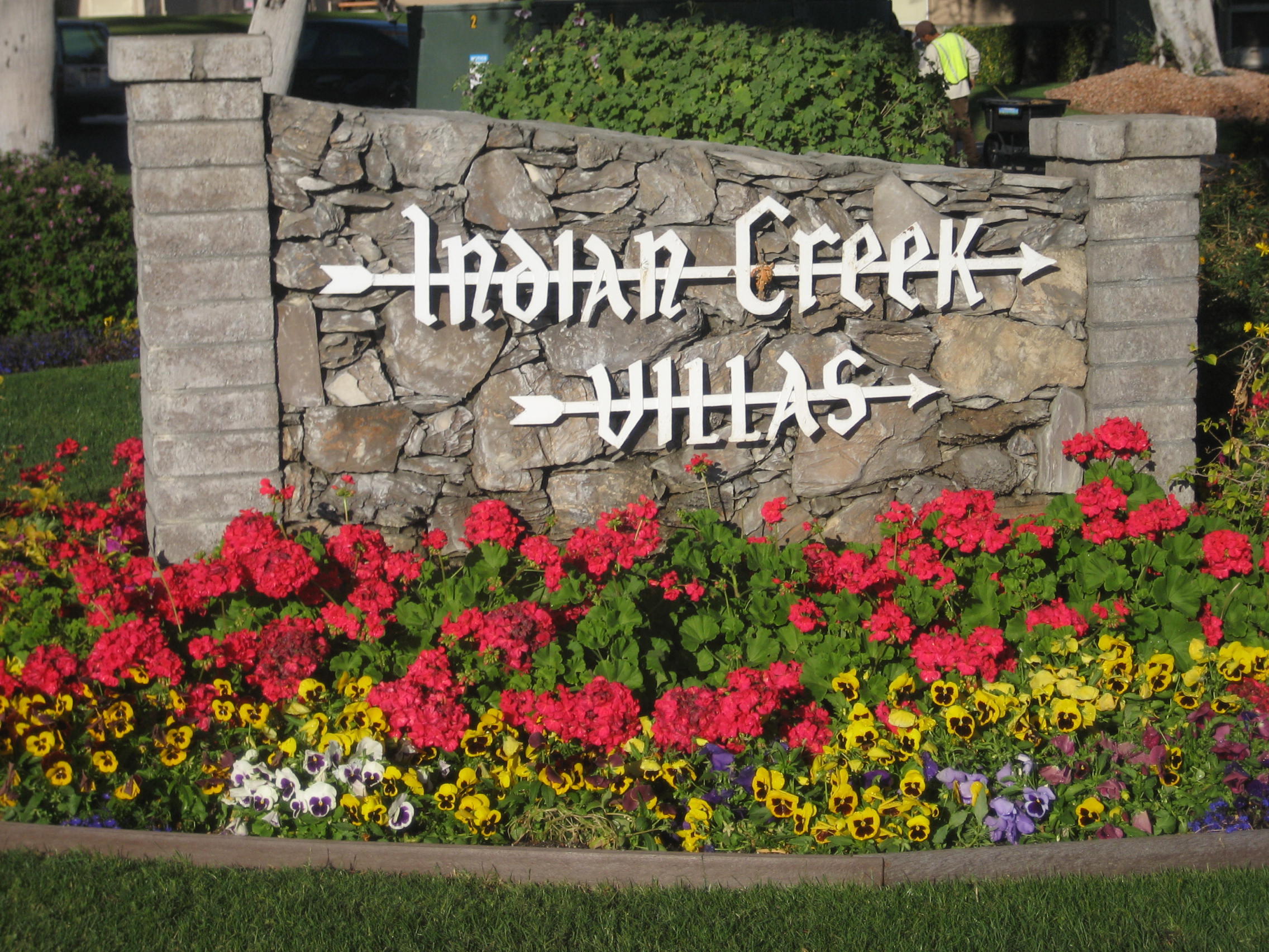 72724 Eagle Road, Unit 2 Palm Desert, CA 92260 - Photo 20 of 29 a street sign that is in front of flowers