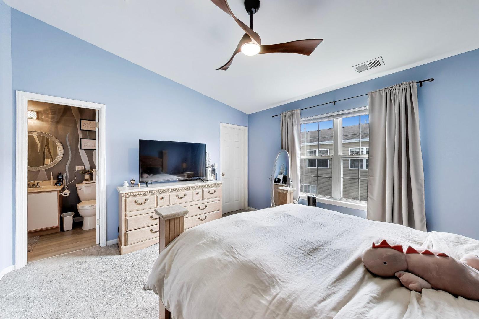 590 Triumph Court Hainesville, IL 60073 - Photo 19 of 25 a bedroom with a large bed and a flat tv screen on dresser