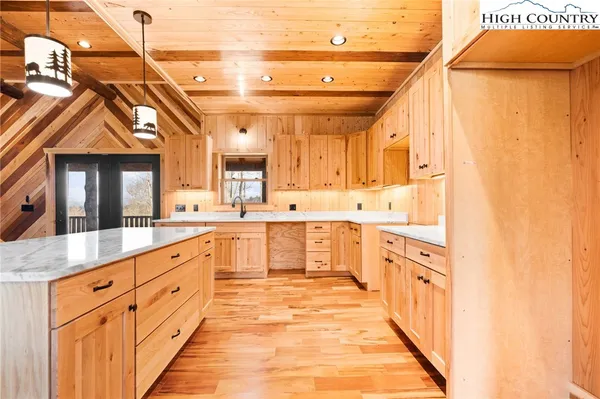 a large white kitchen with kitchen island a sink a counter top space and cabinets