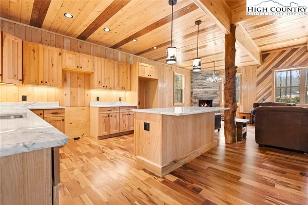 a kitchen with stainless steel appliances granite countertop a sink a stove and a wooden floors