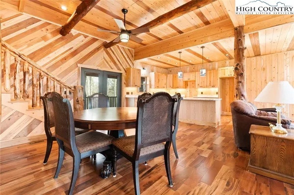 a dining room with furniture a chandelier and wooden floor