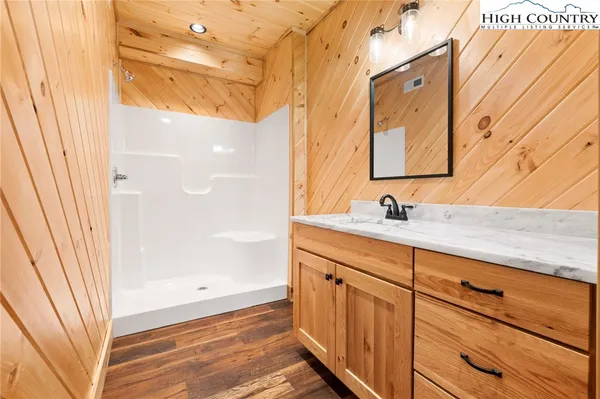 a bathroom with a sink a mirror and a shower