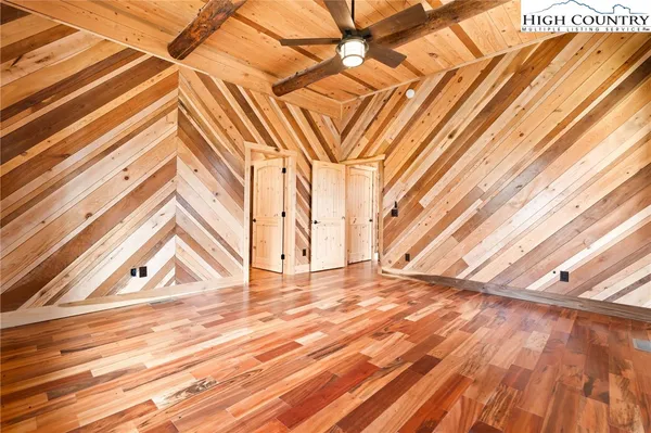 a view of a room with wooden floor and a ceiling fan
