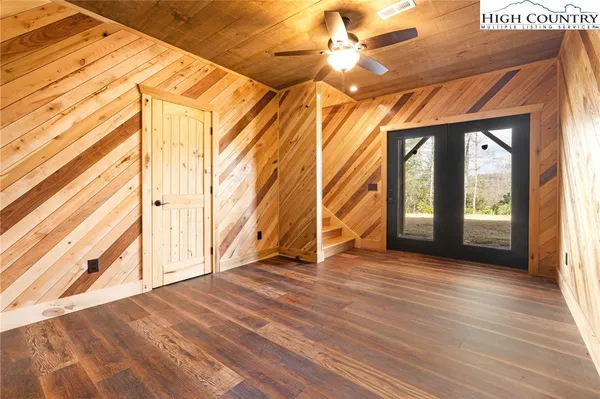 a view of empty room with wooden floor and fan