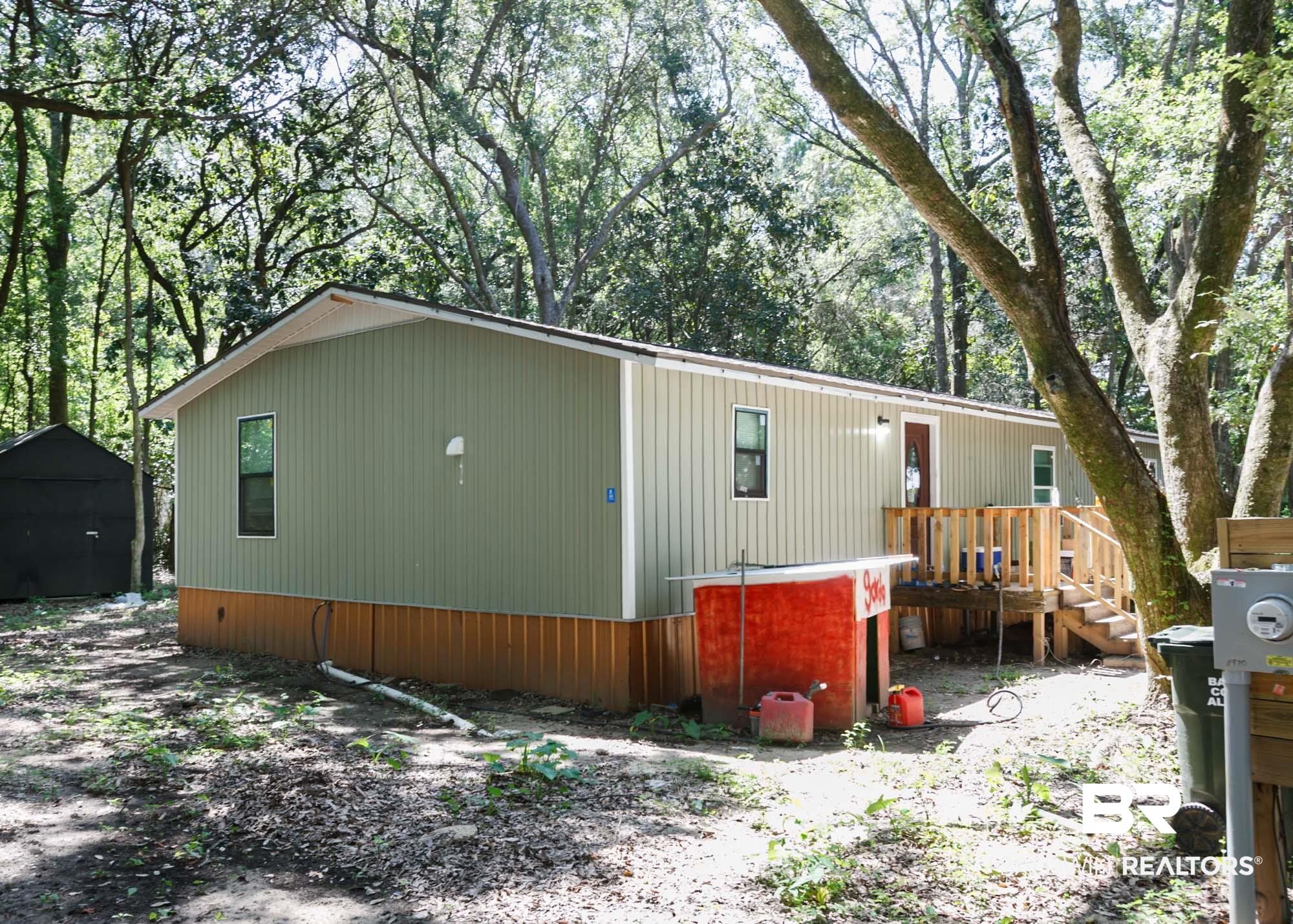 11998 Workman Avenue Foley, AL 36535 - Photo 1 of 59 View of side of home featuring a wooden deck and a storage unit