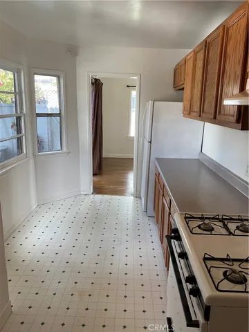 a hallway with a stove top oven a sink and a refrigerator