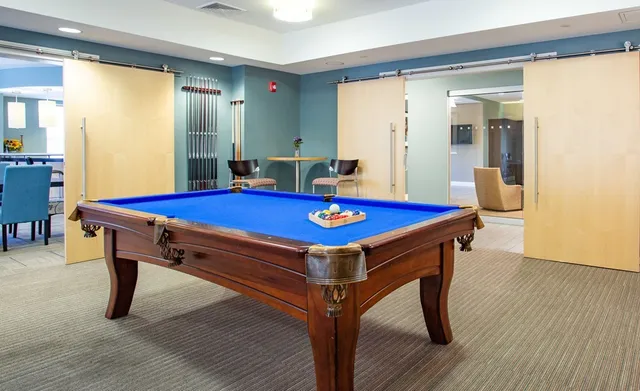 a room with pool table and windows