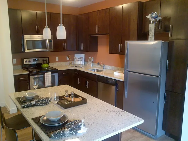 a kitchen with stainless steel appliances granite countertop a sink refrigerator and stove