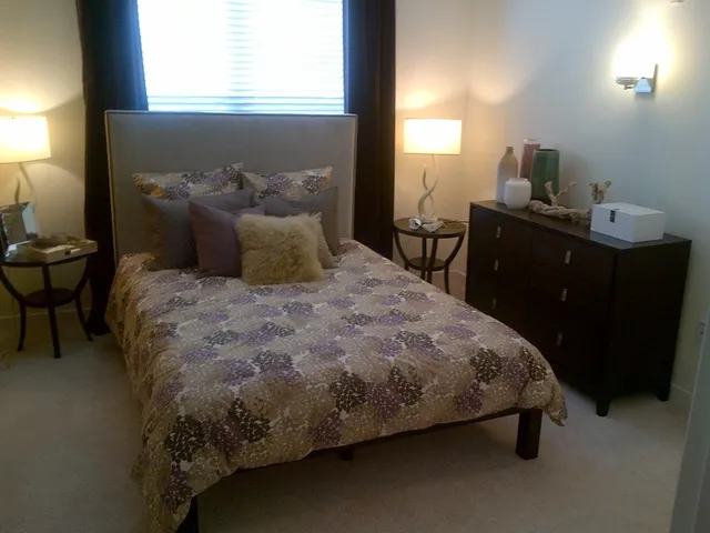 a bed sitting in a bedroom next to a window