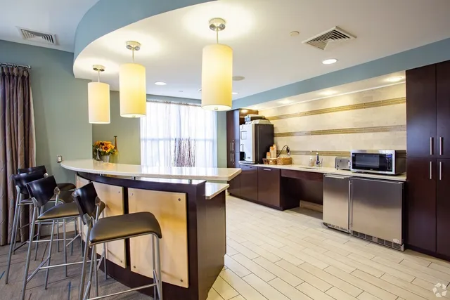 a kitchen with stainless steel appliances kitchen island granite countertop a table chairs in it and wooden floors