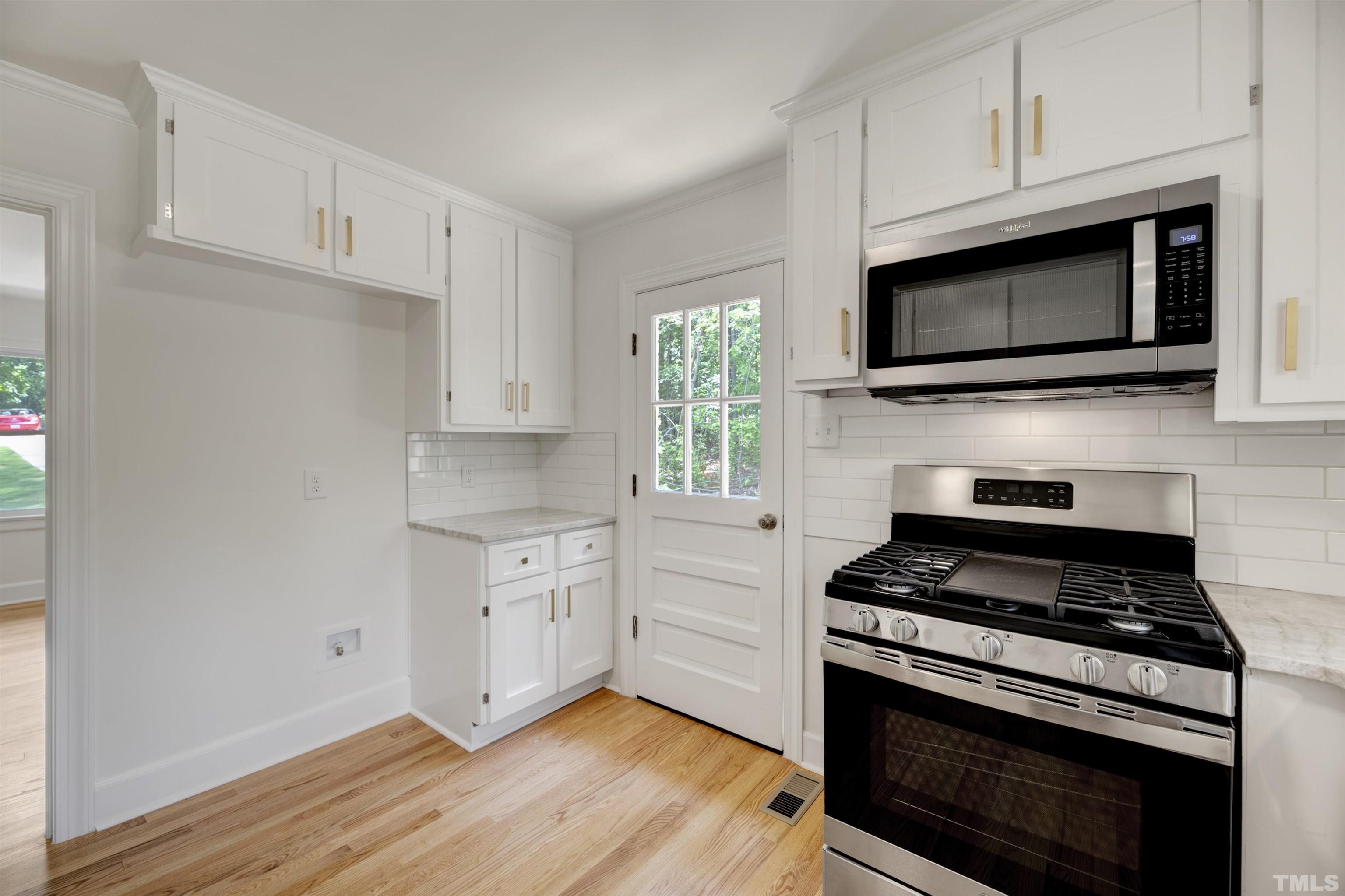 218 Hocutt Road Durham, NC 27703 - Photo 19 of 43 a kitchen with cabinets stainless steel appliances and wooden floor