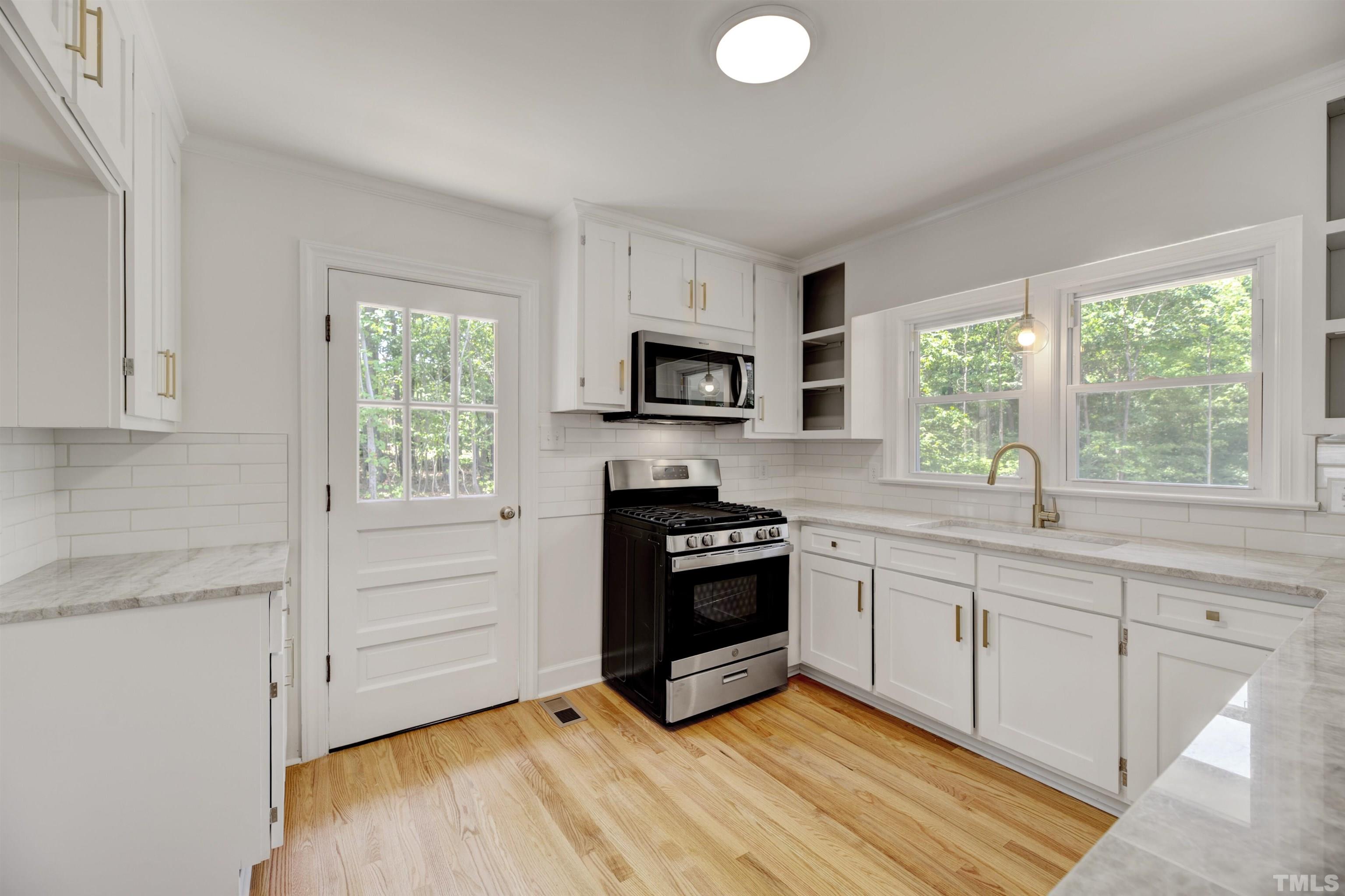 218 Hocutt Road Durham, NC 27703 - Photo 20 of 43 a kitchen with granite countertop a stove a sink and a microwave