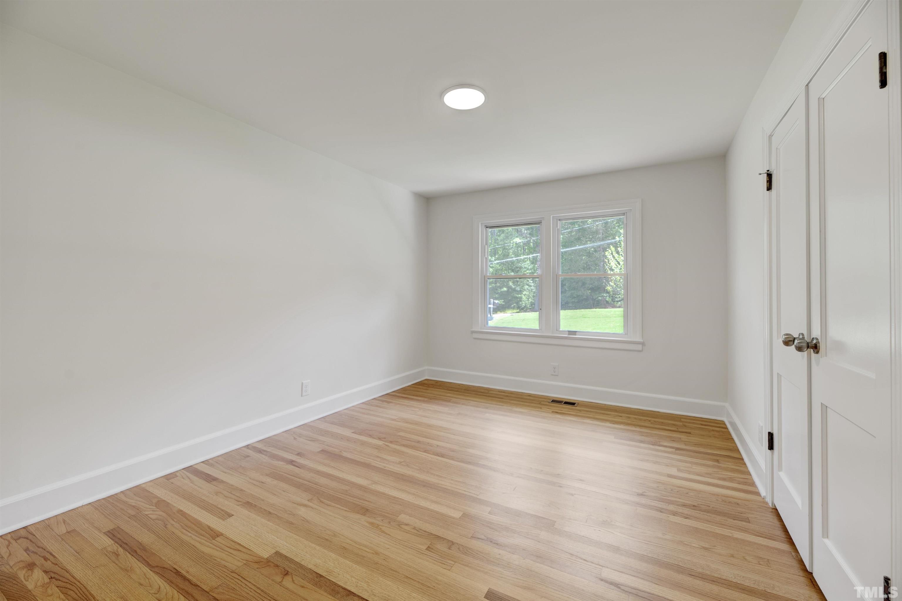 218 Hocutt Road Durham, NC 27703 - Photo 25 of 43 a view of an empty room with wooden floor and a window