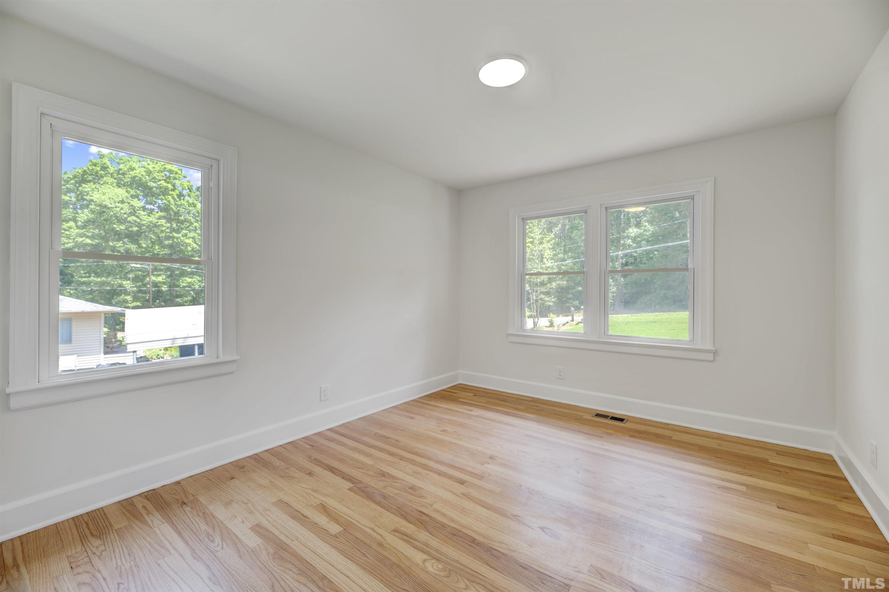218 Hocutt Road Durham, NC 27703 - Photo 27 of 43 an empty room with wooden floor and windows