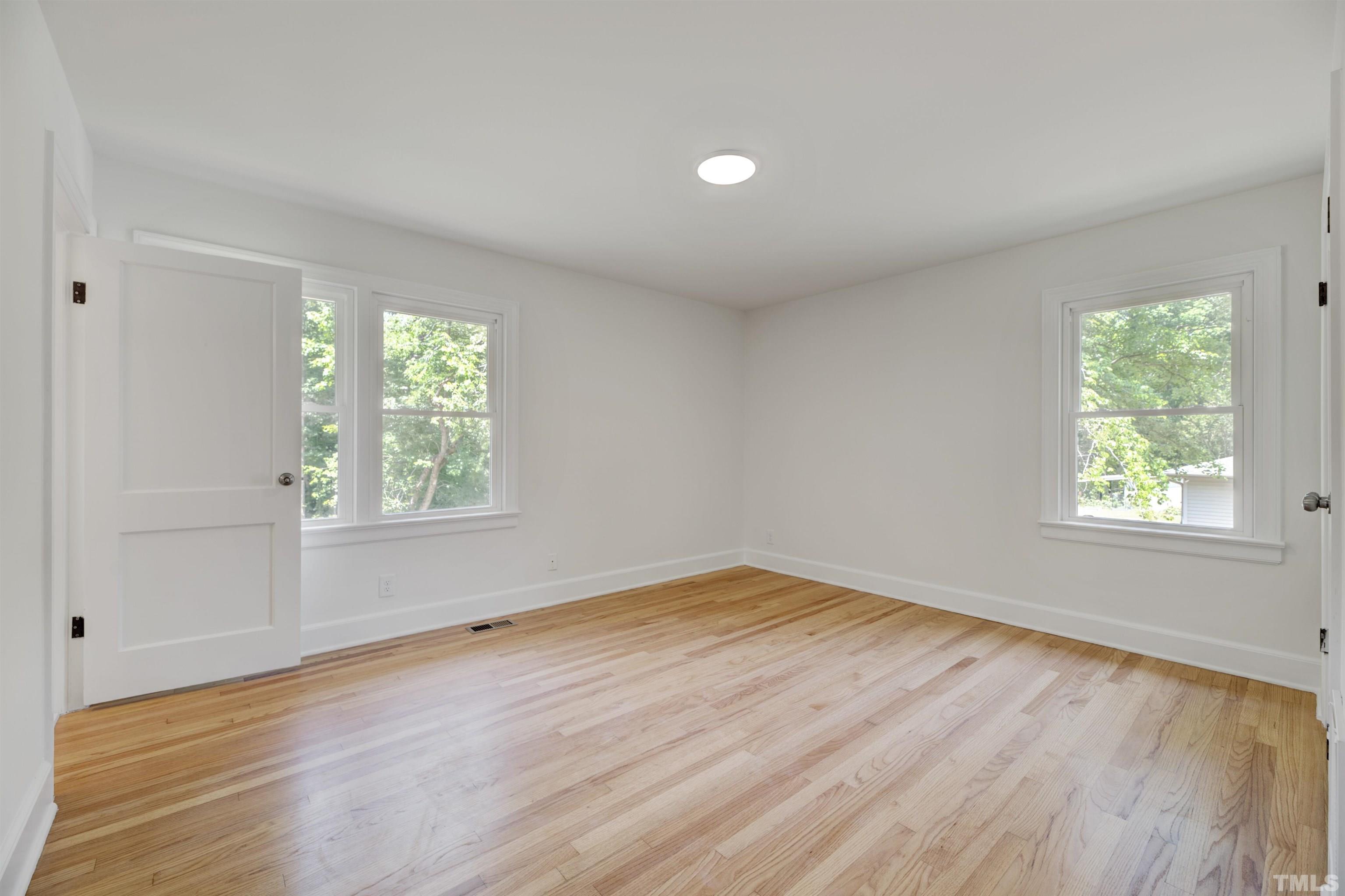 218 Hocutt Road Durham, NC 27703 - Photo 33 of 43 an empty room with wooden floor and windows