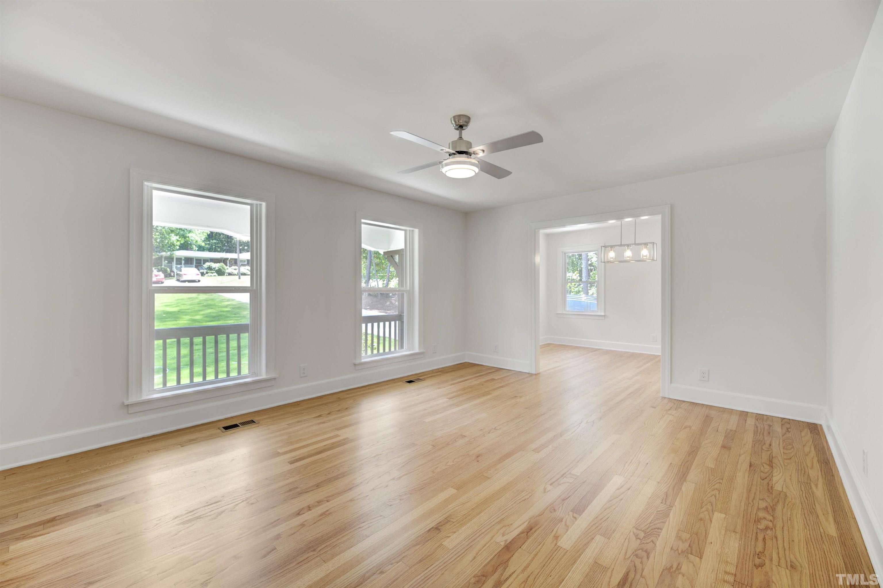 218 Hocutt Road Durham, NC 27703 - Photo 9 of 43 a view of an empty room with a window and wooden floor