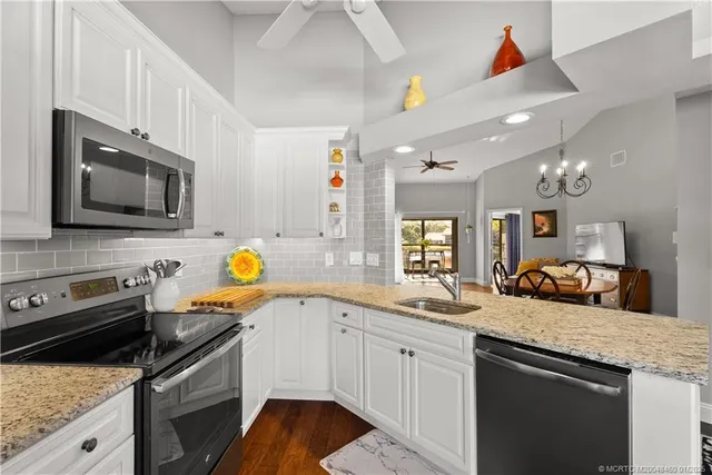 a kitchen with a refrigerator a stove a dining table and chairs with wooden floor