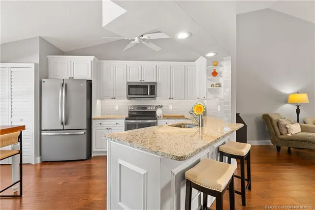 a room with stainless steel appliances kitchen island a table and chairs in it