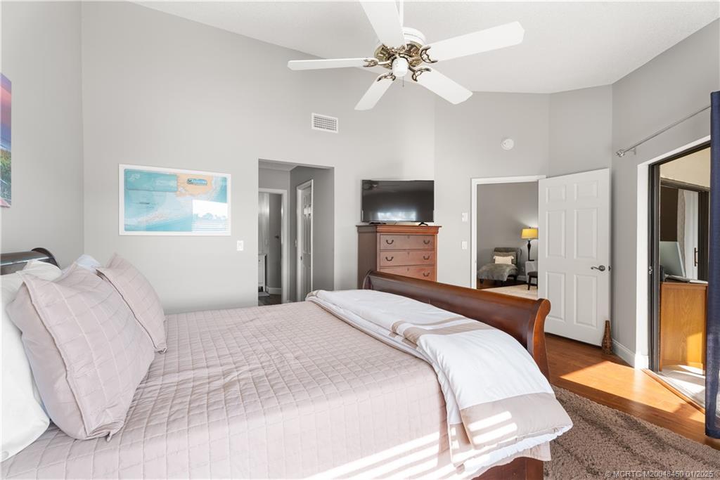 6130 Southeast Martinique Drive, Unit 201 Stuart, FL 34997 - Photo 20 of 36 a bedroom with a bed and a chandelier