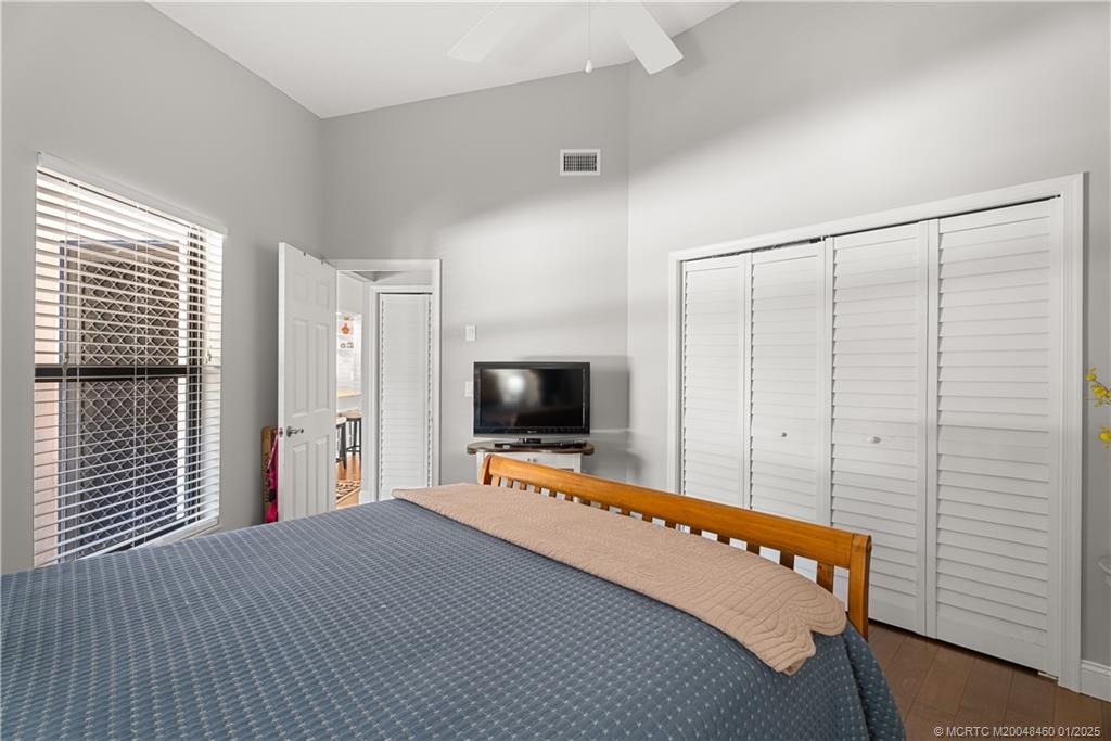 6130 Southeast Martinique Drive, Unit 201 Stuart, FL 34997 - Photo 27 of 36 a room with a bed and a flat screen tv