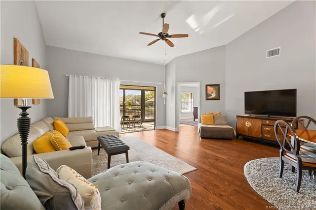 a living room with furniture kitchen view and a window