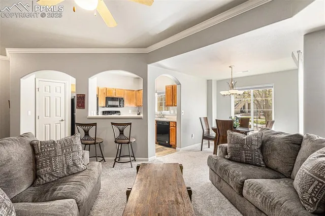 a living room with furniture fireplace and large windows