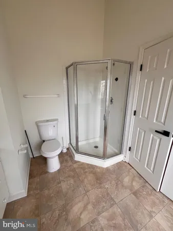 a bathroom with a glass door shower and toilet