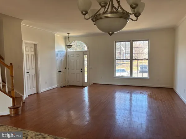 a view of a livingroom with wooden floor and a ceiling fan